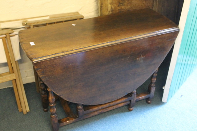 Appraisal: A REPRODUCTION OAK DROP FLAP TABLE with gateleg action and