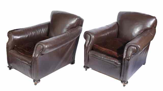 Appraisal: A PAIR OF LEATHER UPHOLSTERED DEEP ARMCHAIRS standing on turned