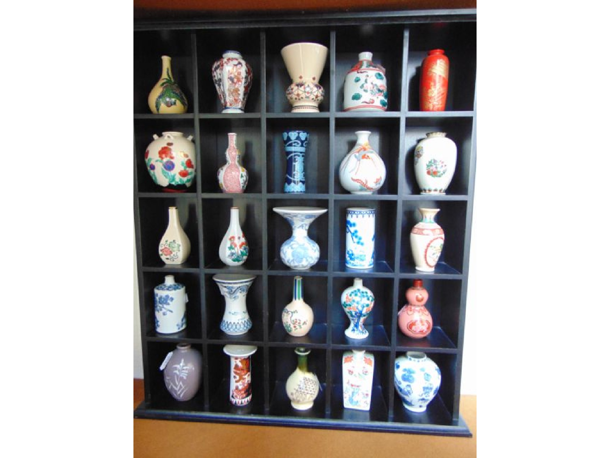 Appraisal: A display case containing a set of twenty five reproduction