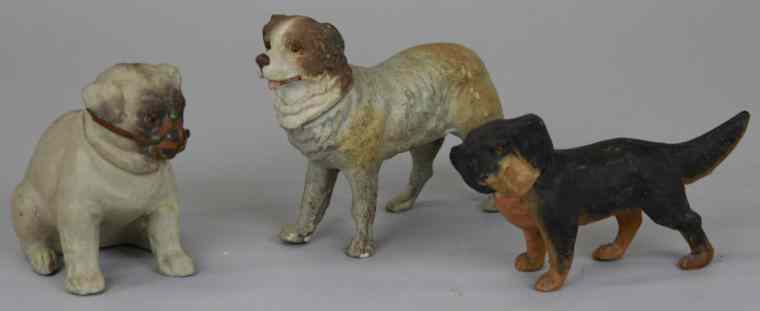 Appraisal: THREE COMPOSITION DOG CANDY CONTAINERS Germany black brown spaniel brown