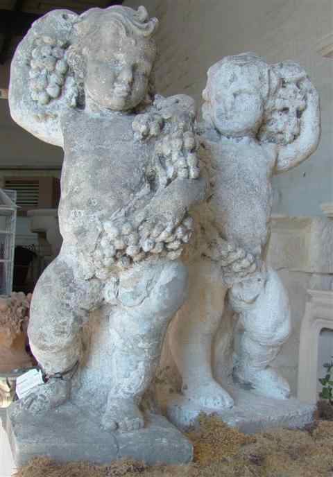 Appraisal: PAIR OF CAST STONE CHERUBS each holding grape clusters h