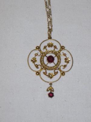 Appraisal: AN EDWARDIAN OPENWORK QUATREFOIL PENDANT centred by a claw set