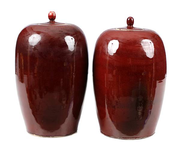 Appraisal: A pair of Chinese ox blood jars with covers height