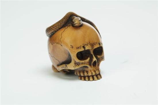 Appraisal: IVORY NETSUKE Japan st half- th century Skull with snake