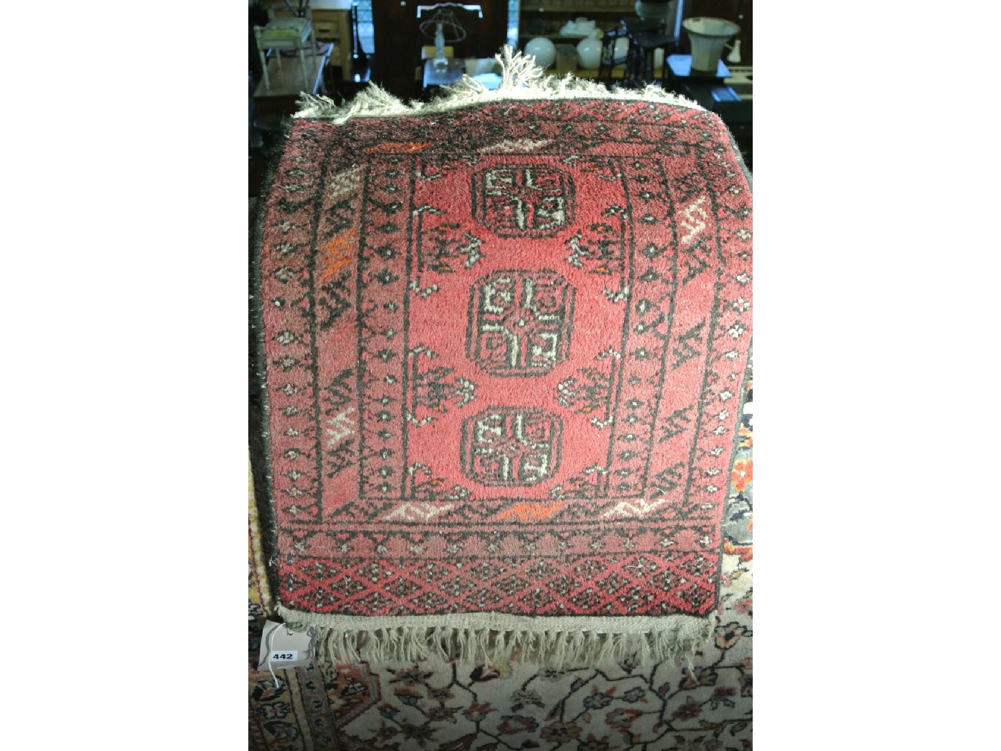 Appraisal: A small Persian rug on a red field with geometric