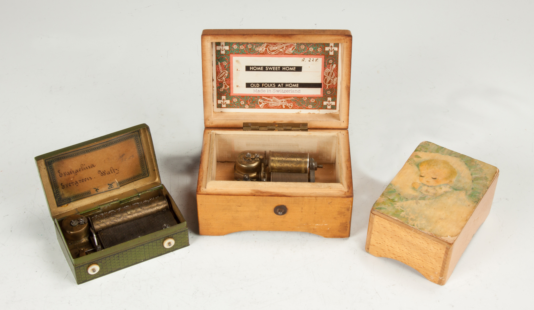 Appraisal: Three Miniature Music Boxes One tin lithographed box two maple