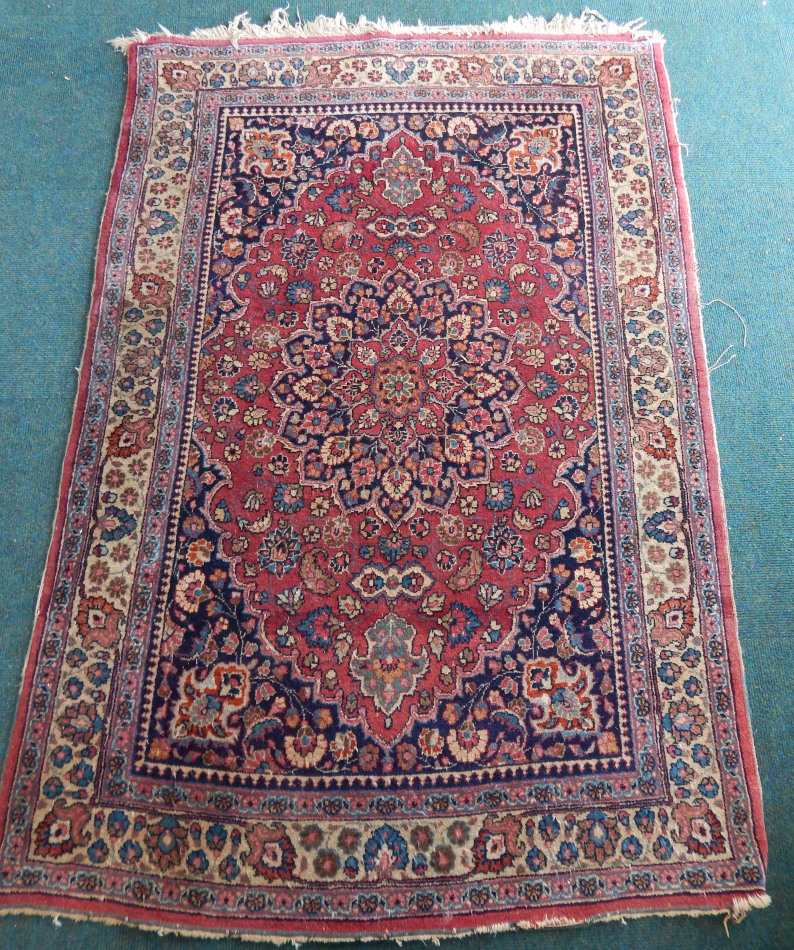 Appraisal: A Persian rug with a central floral medallion in red