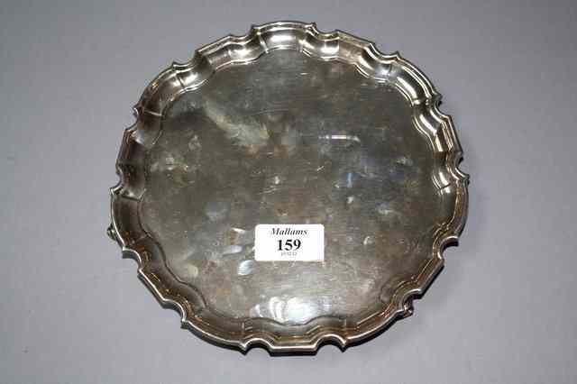 Appraisal: A SILVER SALVER with a Chippendale border and standing on