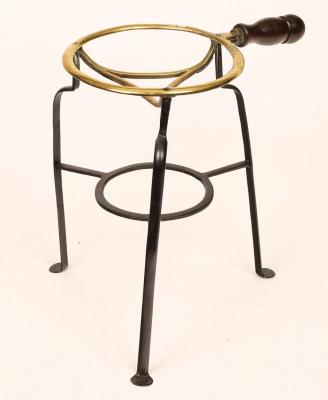 Appraisal: A wrought iron and copper trivet with turned wood handles