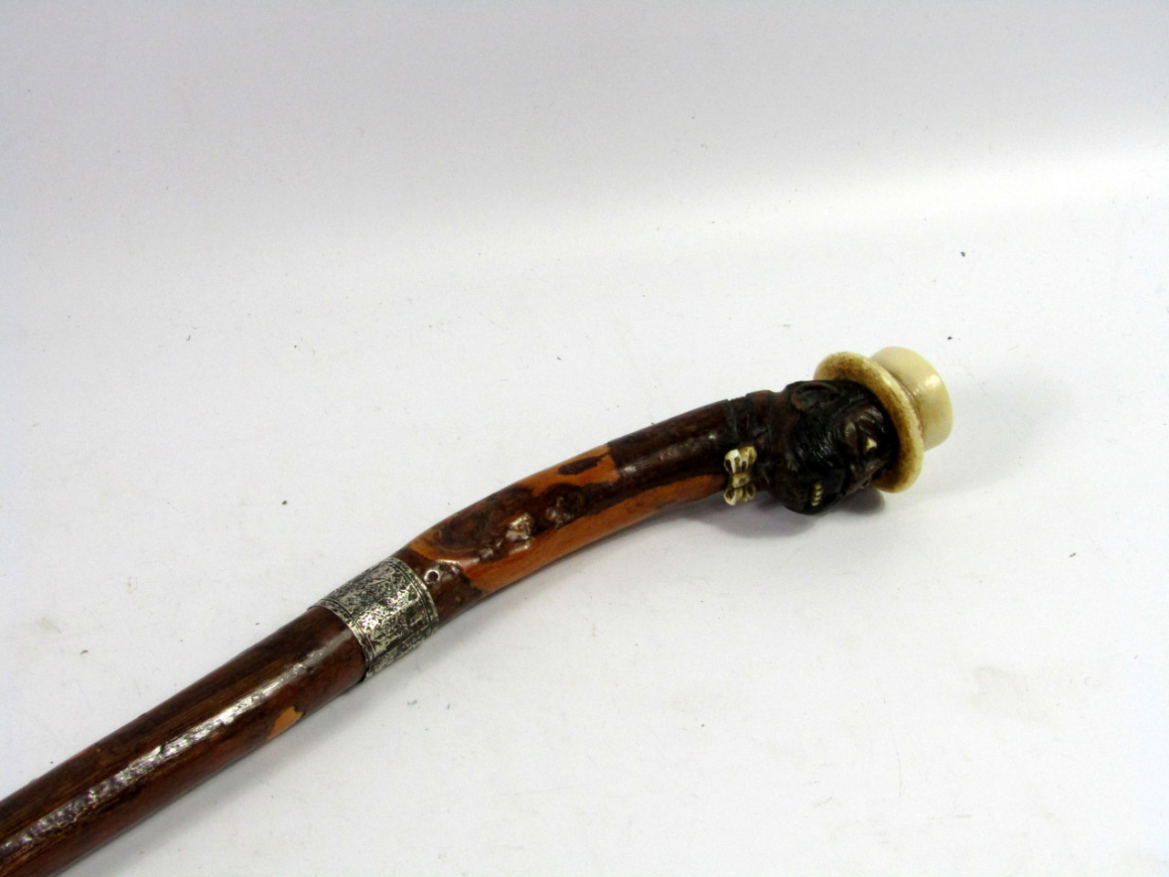 Appraisal: A Victorian walking stick the knop carved as the amusing