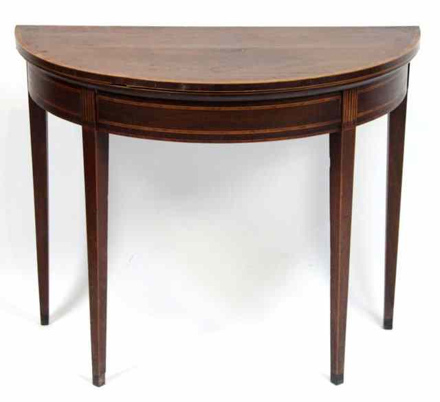 Appraisal: A mahogany half-round card table crossbanded and raised on square