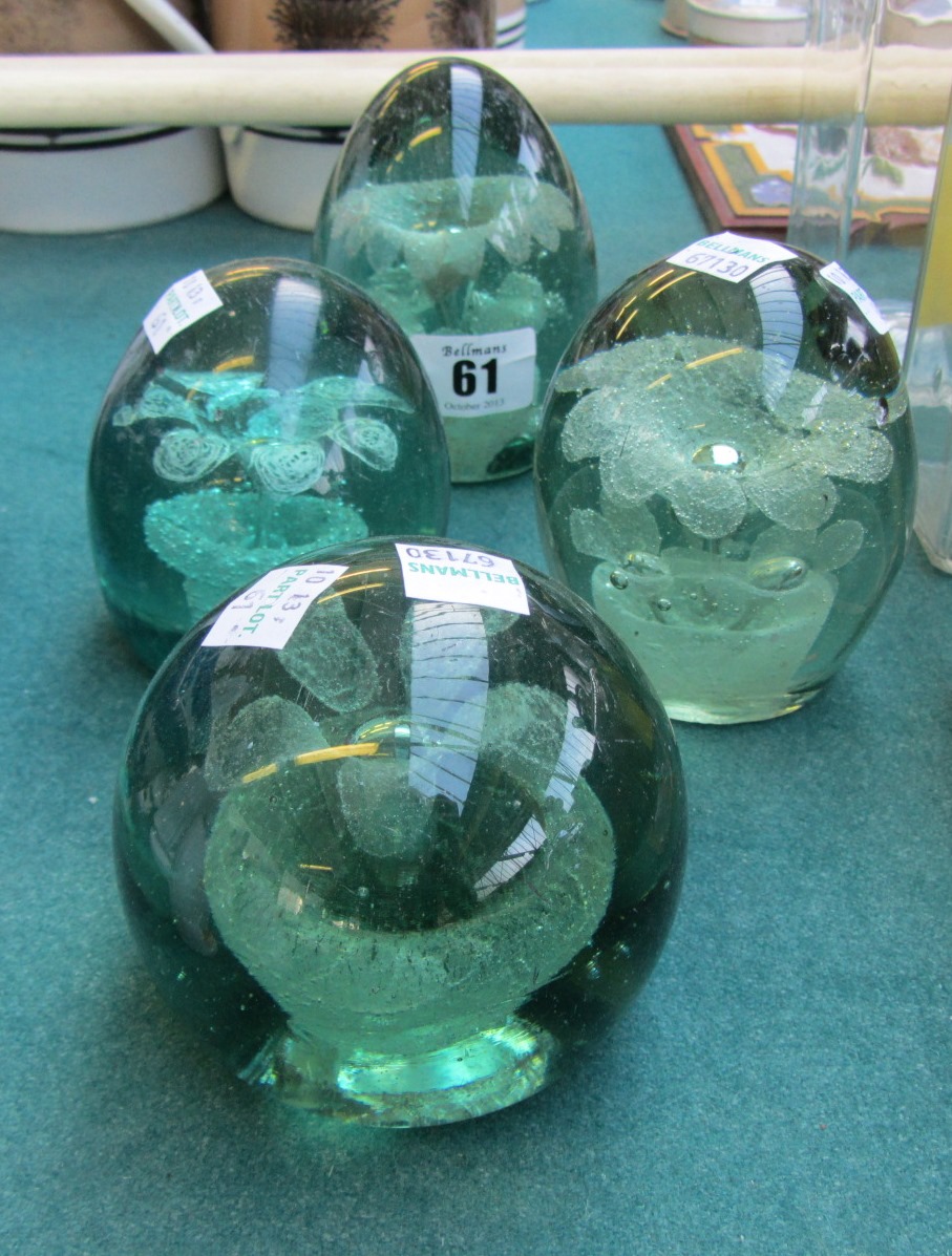 Appraisal: Four Victorian green glass dump paperweights with flower head inclusions