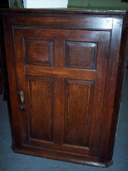 Appraisal: An th Century oak corner cupboard fitted shaped shelves enclosed