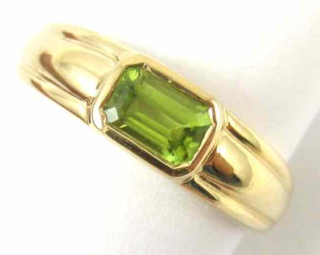 Appraisal: PERIDOT AND FOURTEEN KARAT GOLD RING set with an emerald-cut