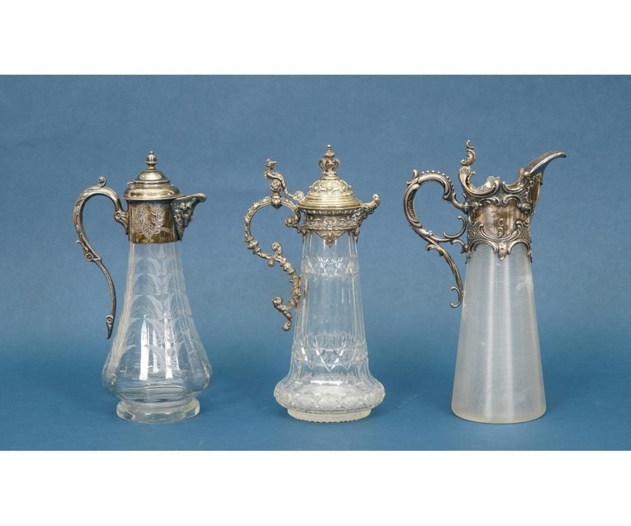 Appraisal: Three ornate silverplate glass claret jugs one ribbed one etched