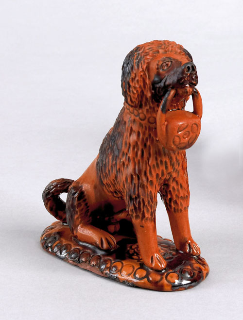 Appraisal: Redware figure of a seated dog holding a basket th