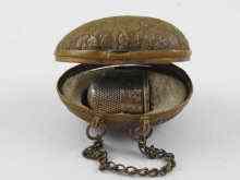 Appraisal: A gilt metal egg shaped thimble case with silver thimble