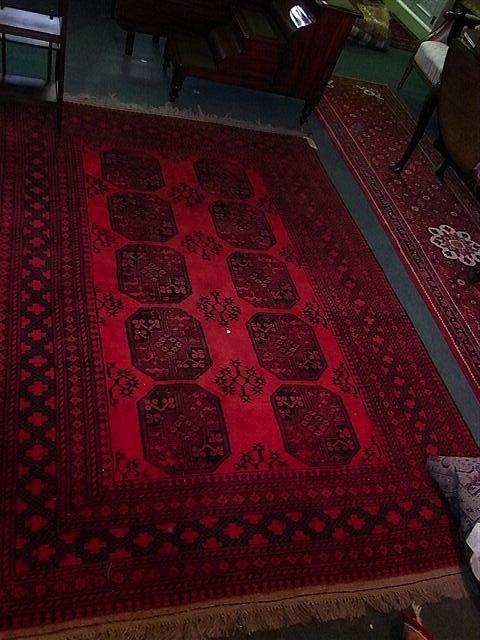 Appraisal: AN AFGHAN RED GROUND RUG with central elephant foot designs