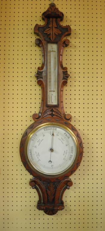 Appraisal: A late Victorian aneroid barometer in a carved oak case