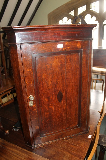 Appraisal: A GEORGIAN OAK CORNER CUPBOARD enclosed by single panel door