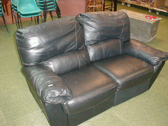 Appraisal: A black leather finished reclining two seater sofa