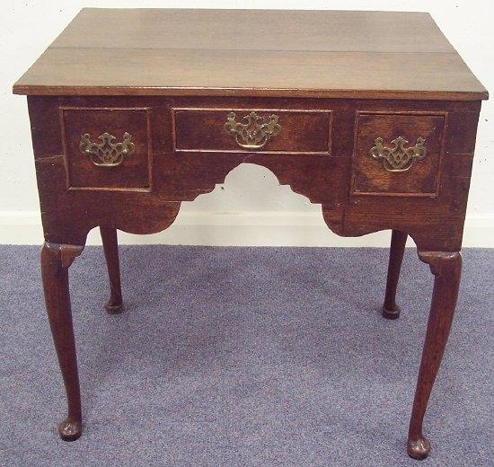 Appraisal: An oak kneehole table fitted three drawers with shaped apron