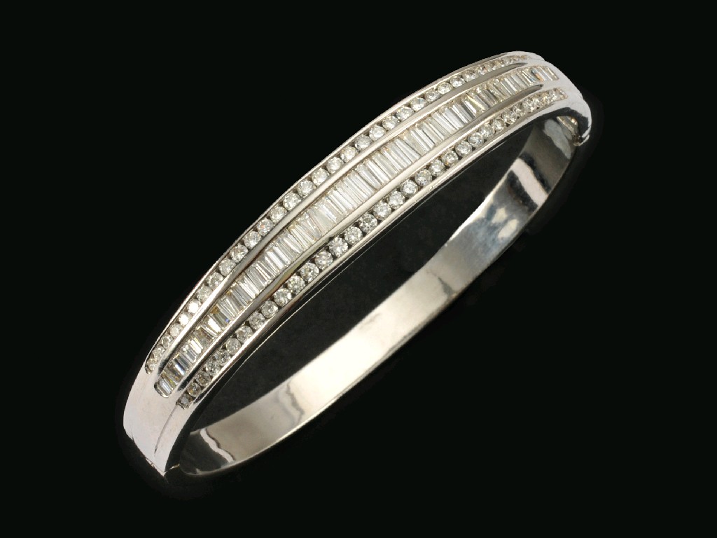 Appraisal: A Continental Diamond hinged Bangle the front channel-set central row