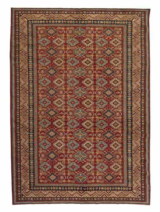 Appraisal: A Pakistani Wool Rug having repeating stylized foliate and geometric