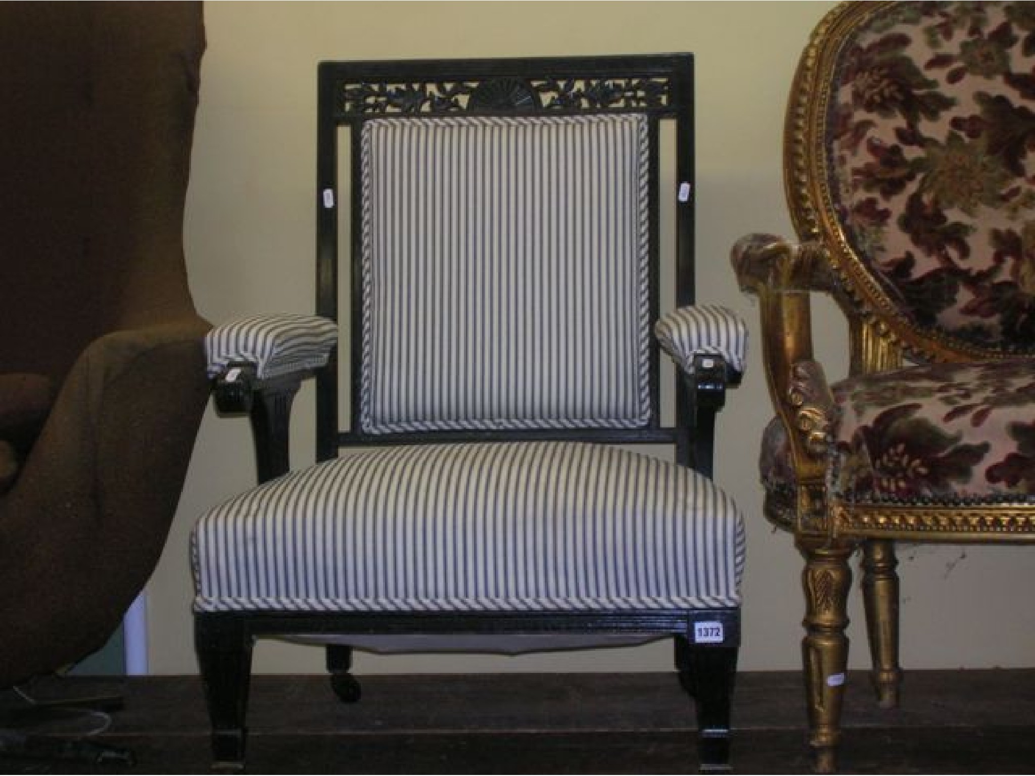 Appraisal: An Edwardian ebonised elbow chair with carved and pierced detail