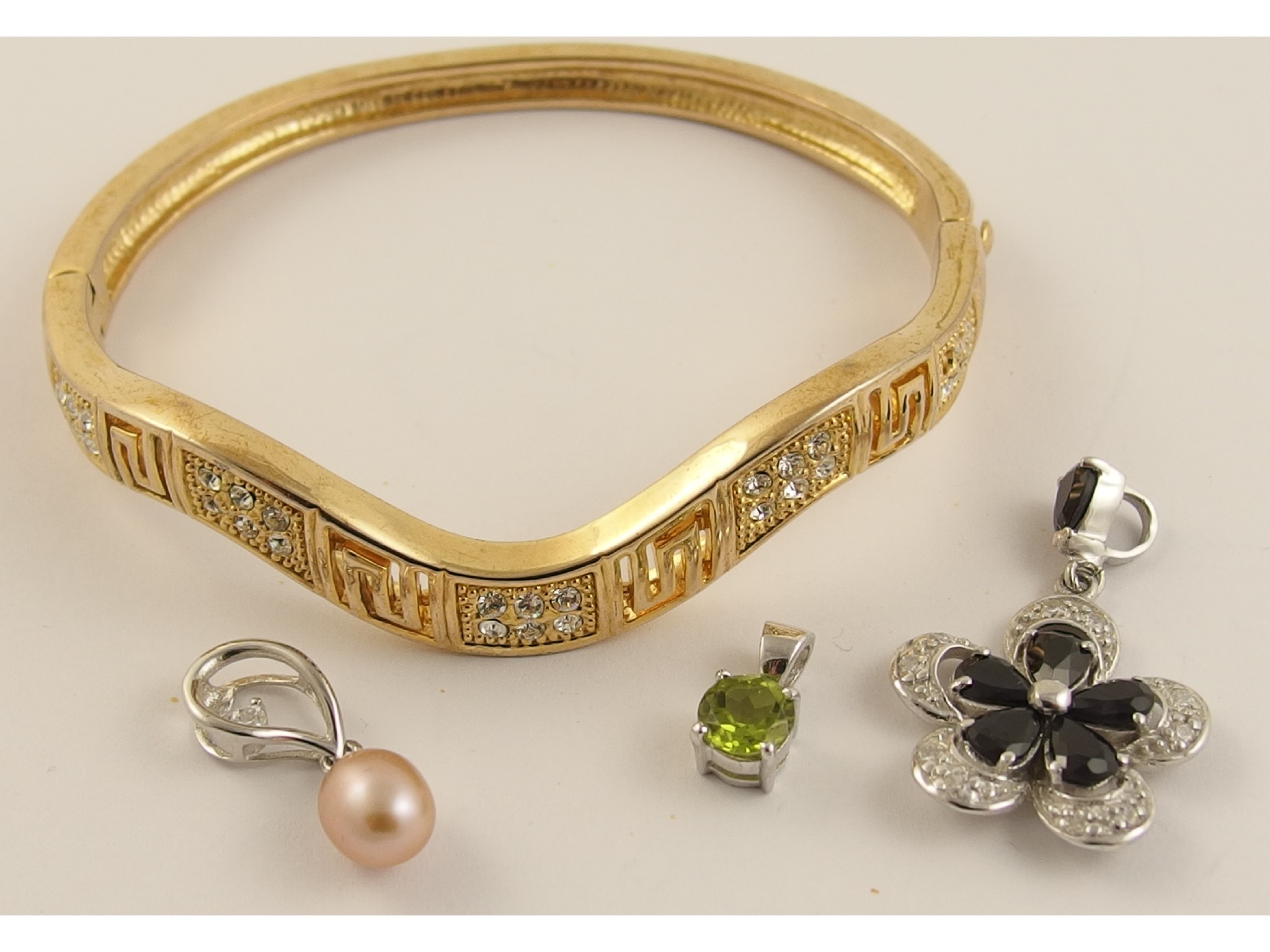 Appraisal: A costume jewellery bangle and three silver gem set pendants