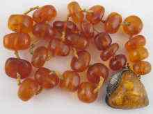 Appraisal: An amber necklace approx cm together with a silver mounted