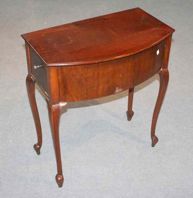 Appraisal: AN EDWARDIAN MAHOGANY BOW FRONTED SIDE TABLE with one hinged