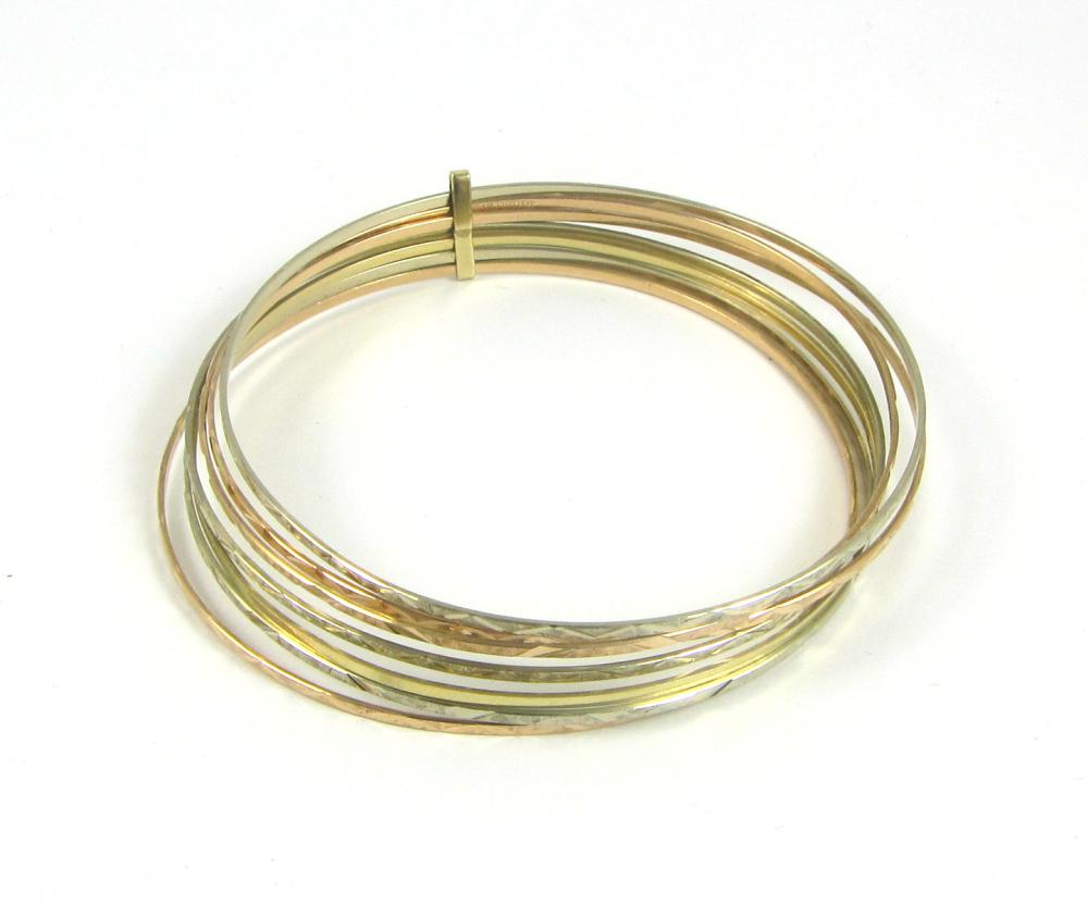 Appraisal: TRI-COLOR FOURTEEN KARAT GOLD SEVEN-BANGLE BRACELET engraved finish the seven