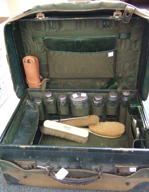 Appraisal: A leather travelling toilet case fitted with seven mostly silver