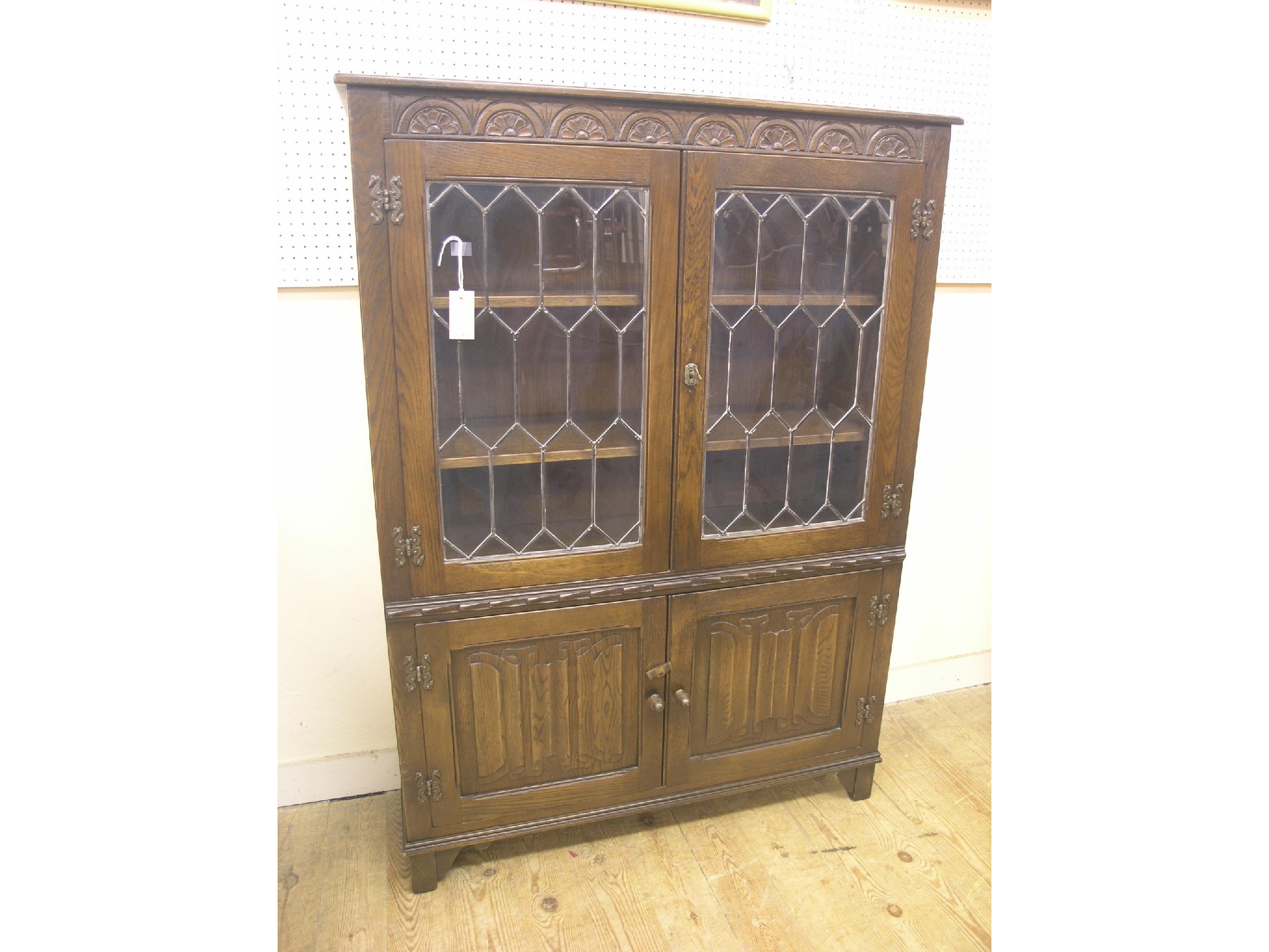 Appraisal: A Jaycee dark oak linenfold display cabinet carved lunette frieze