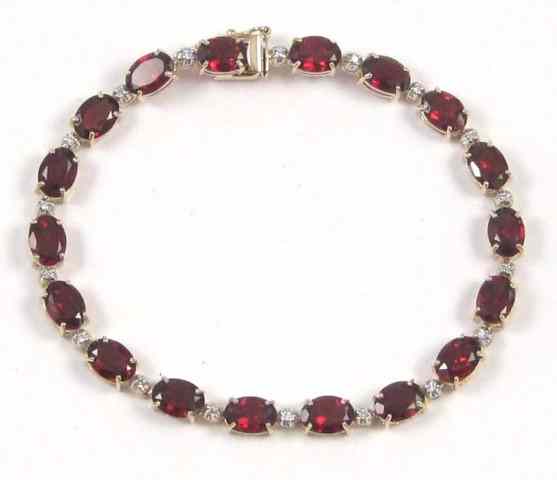 Appraisal: GARNET AND DIAMOND BRACELET k yellow gold set with oval-cut