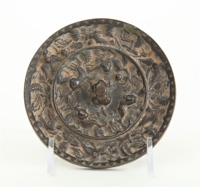 Appraisal: CHINESE RELIEF-CAST BRONZE MIRROR The raised central boss encircled by