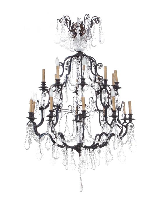 Appraisal: French bronze and crystal twenty-light chandelier scrolling frame mounted with