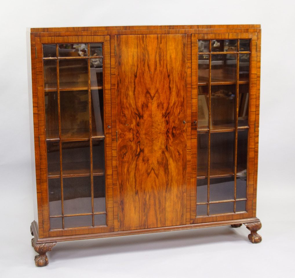 Appraisal: A walnut bookcase early thC with a central quarter veneered