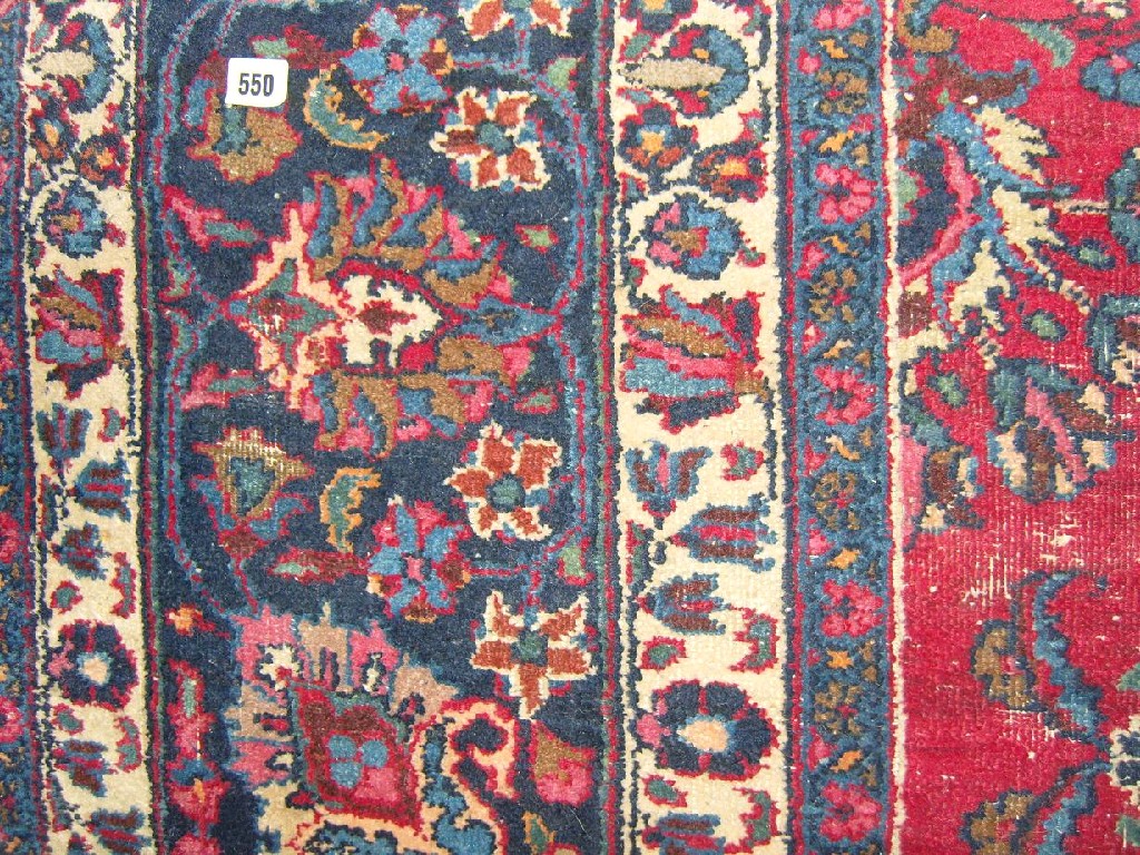 Appraisal: A red ground eastern wool rug with stylised floral decoration