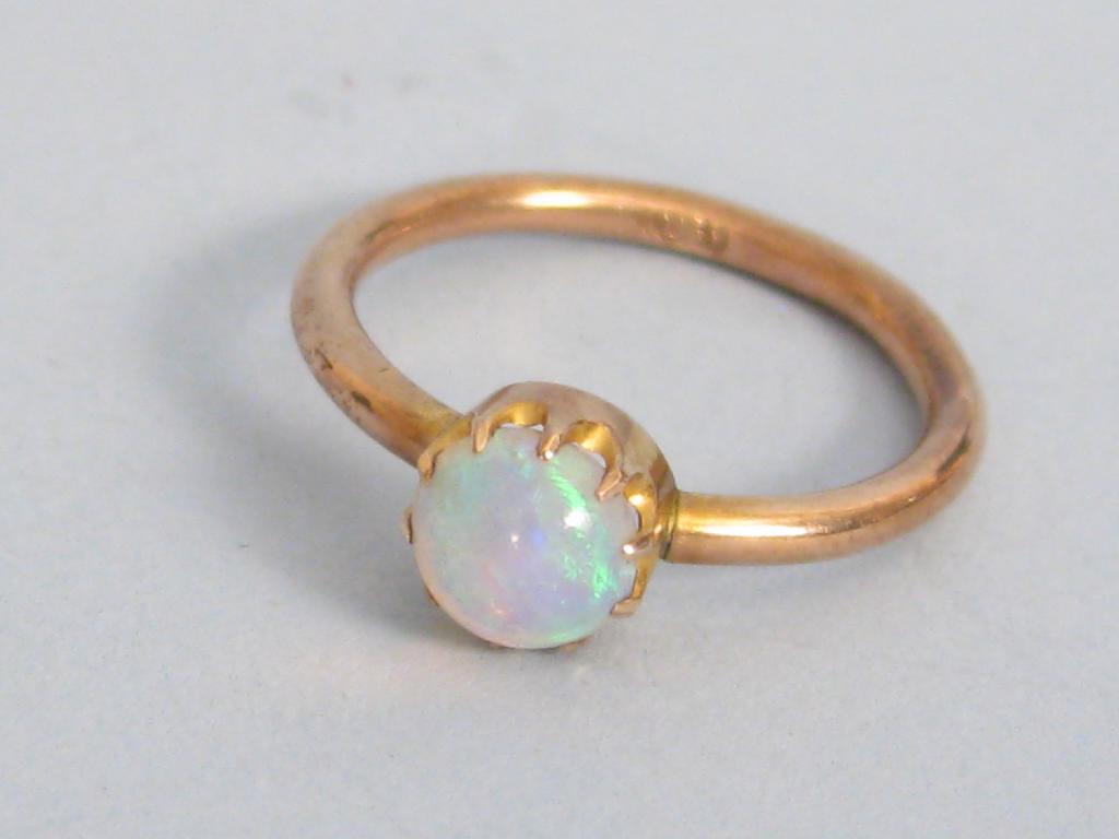 Appraisal: A single stone Opal Ring the cabochon opal simply claw-set