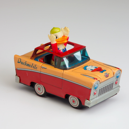 Appraisal: Donald Duck figure in car in the Disney style Made