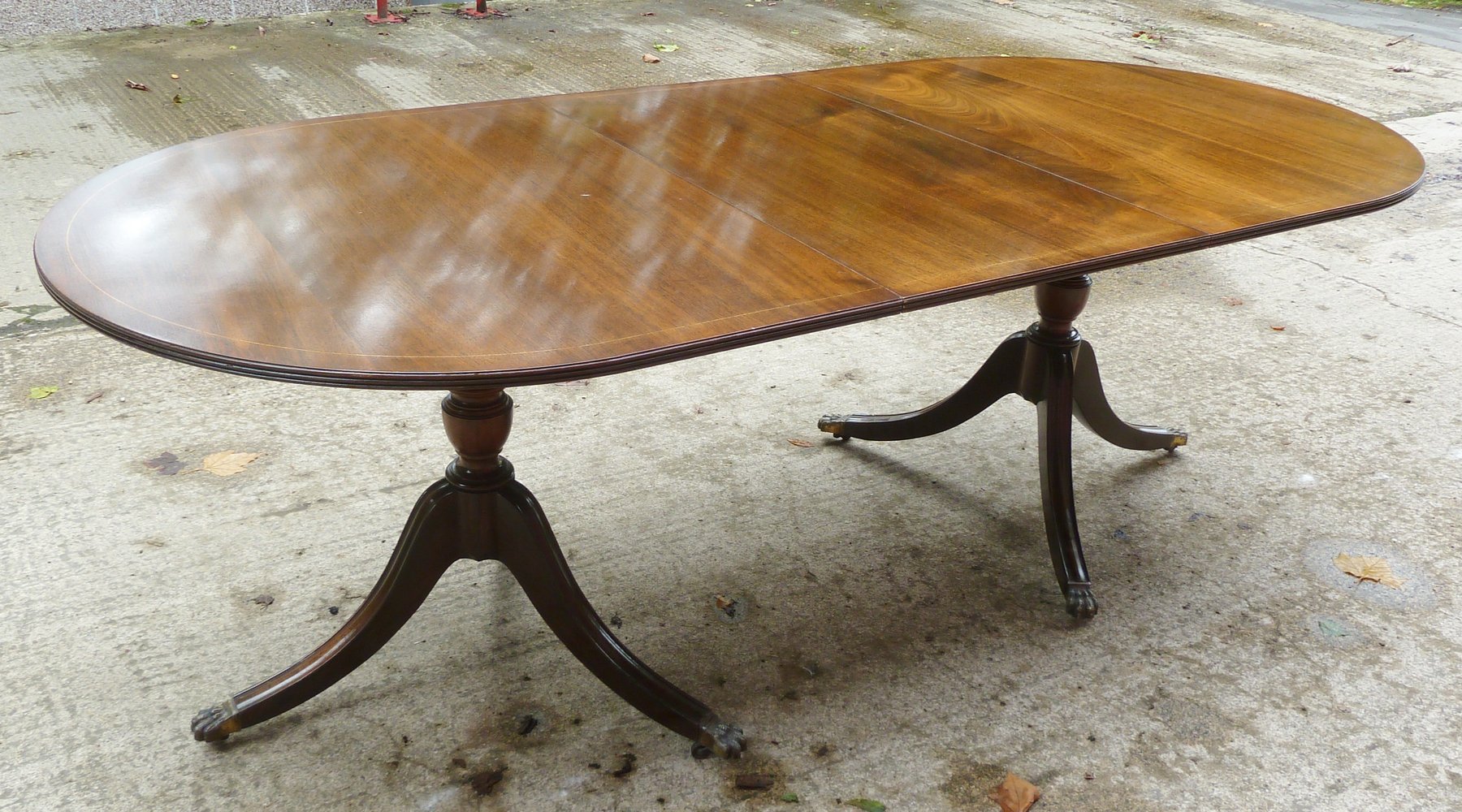 Appraisal: A reproduction two-pillar dining table in the Regency style with