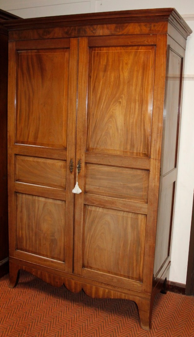 Appraisal: A late thC mahogany wardrobe the overhanging cornice raised above