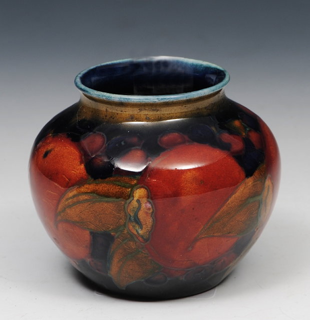 Appraisal: A MOORCROFT SMALL VASE decorated pomegranates on a cobalt blue