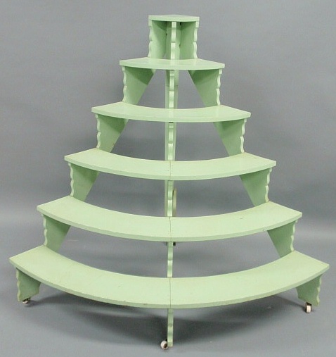 Appraisal: Six-tier half-round plant stand with green paint and porcelain wheels