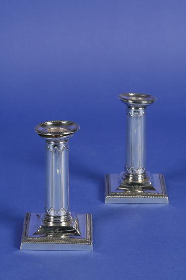 Appraisal: A PAIR OF EDWARDIAN LIBRARY CANDLESTICKS with cylindrical fluted stems