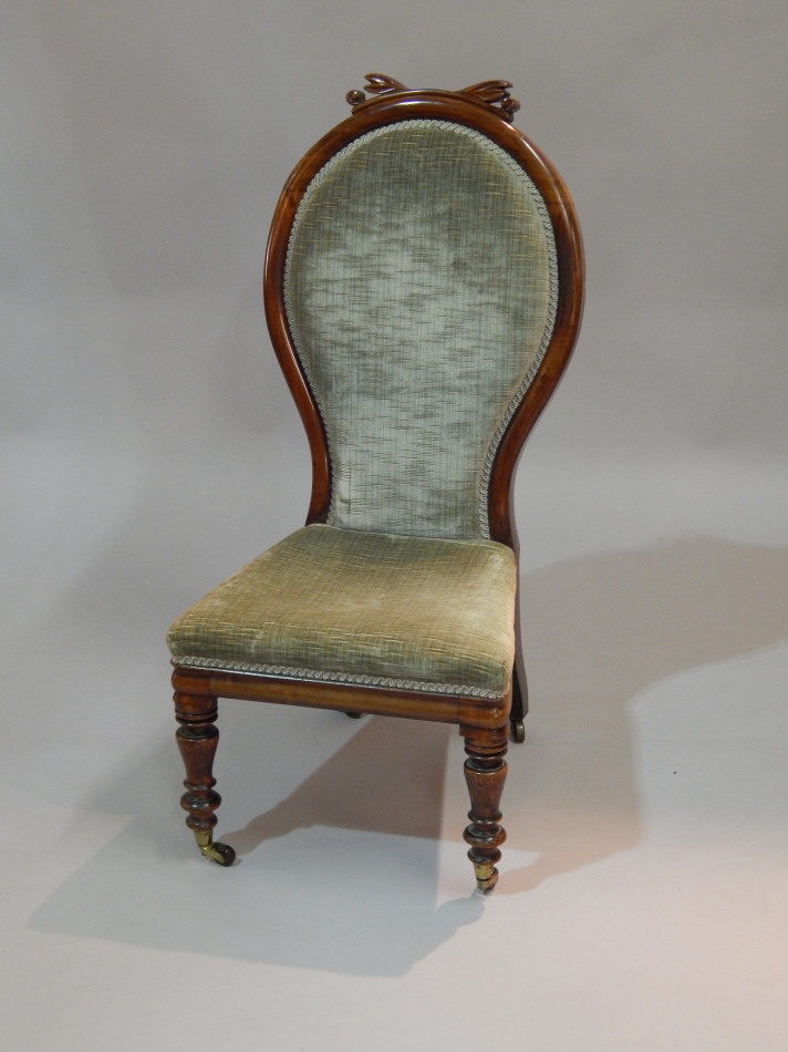 Appraisal: A Victorian walnut nursing chair with a shaped spoon back