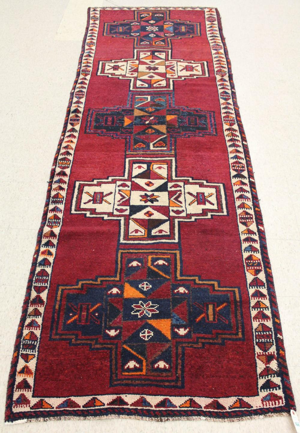 Appraisal: PERSIAN TRIBAL RUNNER five cruciform medallions on plain red ground