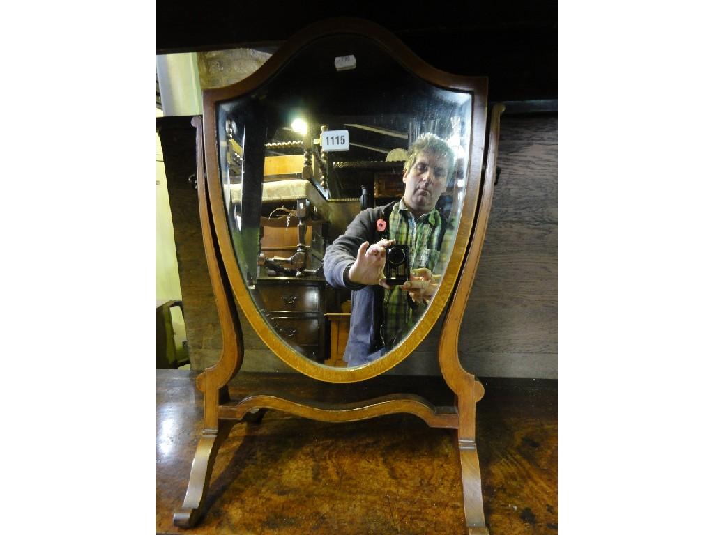 Appraisal: A Georgian style mahogany shield shaped toilet mirror with bevelled